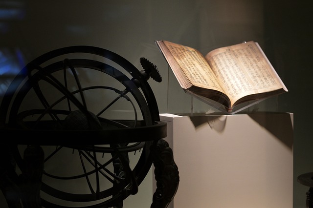 ein Buch neben einem alten Astrolabium